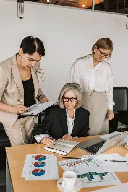 A diverse team collaborating on digital marketing strategies at a desk, using laptops and tablets.